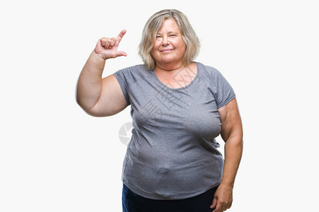 资深大白种女人在孤立的背景微笑和自信的手势用手指做大小标志图片