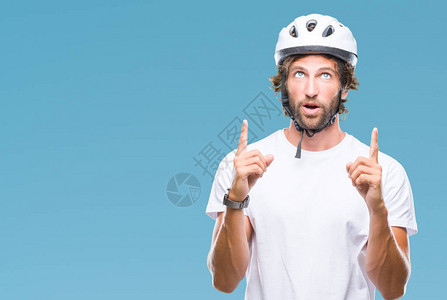 身着安全头盔的英俊大帅气的骑自行车男子在孤立的背景之下惊异地抬头图片