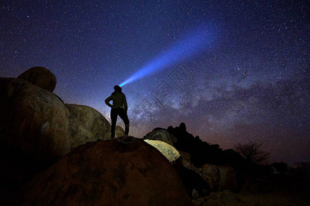孤独的女人在圆形岩石结构上凝视银河和星的轮廓图片