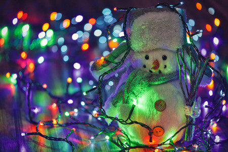 小玩具雪人在多彩的圣背景图片