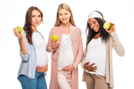 怀着微笑的孕妇将水果握在白背景图片