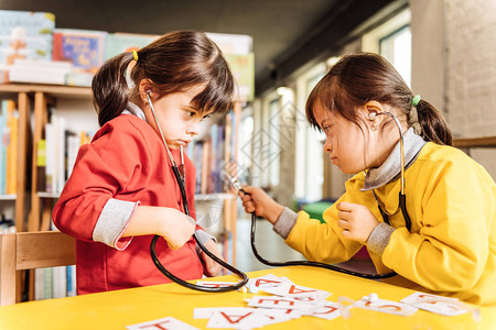 在幼儿园玩患有唐氏综合症的黑眼睛愉快的孩子图片