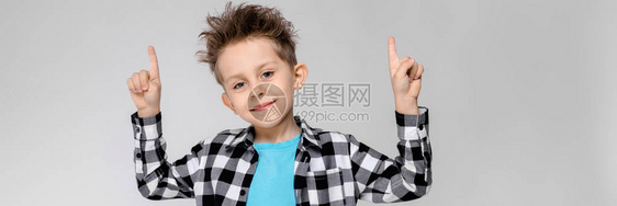 灰色背景的迷人快乐的孩子男孩的头发都竖起来了这个男孩有一个发型男孩用图片