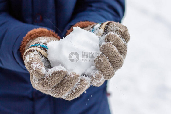 一只穿手套的女孩拿着雪球在明晴图片