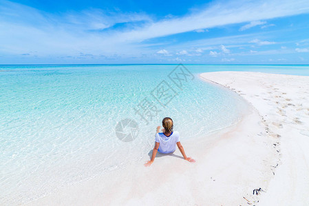 女人在风景秀丽的白色沙滩上晒日光浴图片