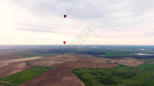 鸟瞰图热气球在美丽的天空和日落的乡村田野上空浮空图片