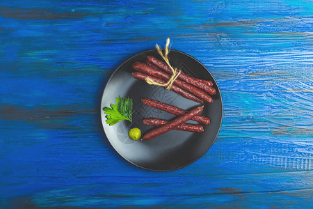 用盘子里的猪肉在深蓝色木头表面做成的传统油条图片