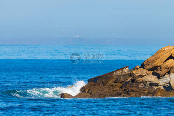 深蓝色的海浪击中峭壁图片