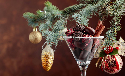 各种精美的巧克力糖在高脚杯中用肉桂棒和巧克力做圣诞装饰圣诞假期的静图片