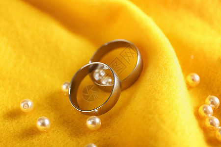 彩色布上有珍珠的金戒指背景图片