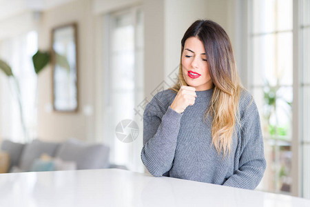 在家中穿冬毛衣的年轻美女感到不舒服图片