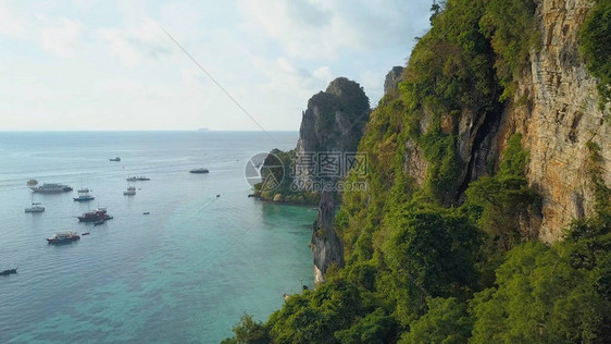 熙攘的旅游船在风景如画的石灰岩岛屿悬崖附近航行图片