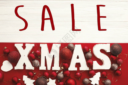 红色平躺上的圣诞大甩卖文本和圣诞白色标志圣诞节特别折扣优惠红色和的小玩意装饰品背景图片