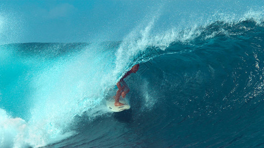 职业冲浪员骑着翡翠巨浪冲向大溪地热带海岸的令人叹背景图片