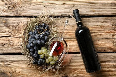 杯子和酒瓶红酒木制桌图片