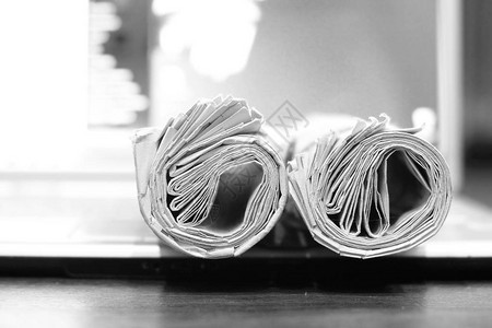 报纸和电脑折叠和卷起的纸张和杂志以及打开的笔记本电脑不同信息来源的新闻概念图片
