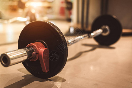 健身运动健身房地板上的一组黑色重钢杠铃对象和锻炼的概念锻炼训练和健美运动员重量强度道具的运图片