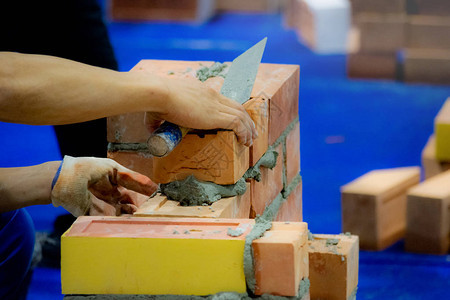 Bricklayer安装砖头Bricklayer工人在外墙上安装砖图片