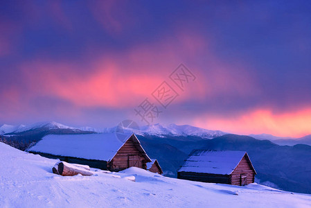 山村的冬天满是雪的旧木屋日落美丽云图片