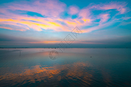 海上美丽的落日天空蓝天和紫色橙色和黄色的云黄昏时分图片