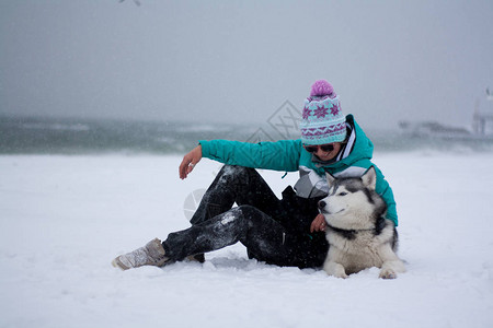 年轻女人在海边滩的雪上玩得开图片