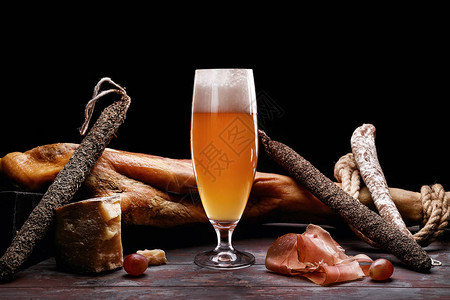一杯轻啤酒泡沫一条腿帕马火腿昂贵的香肠品种和有霉菌图片
