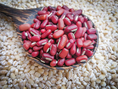 木材勺子谷物或谷类豆子上的红肾豆籽图片