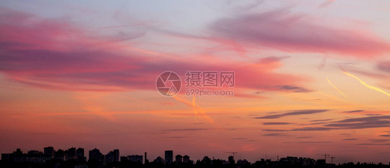 与戏剧天空日落的城市景观建筑工地的建筑物和起重机的轮廓城市图片