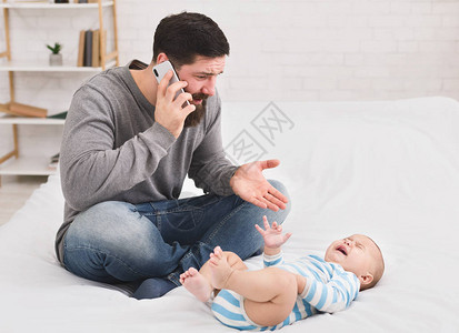 年轻父亲对哭着的婴儿生气图片