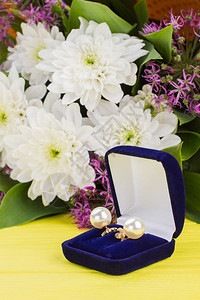 礼物盒中的珍珠耳环和鲜花图片