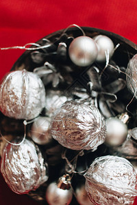 红色背景上带有银球小玩意和松果的圣诞装饰图片