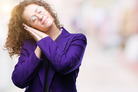 身着校服和眼镜的年轻黑发女学生在孤立的背景中沉睡于疲倦的梦里图片