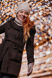 街上带着圣诞灯的年轻快乐女人图片