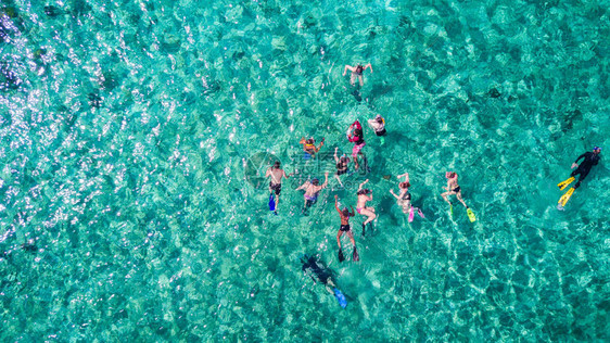 在加勒比海热带蓝色水域浮潜的一群人的空图片