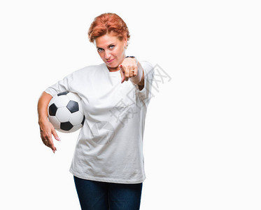 迷人的高加索红发女在孤立的背景下拿着足球图片