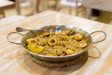西班牙巴塞罗那木制桌上的锅里传统海产食品烤肉图片