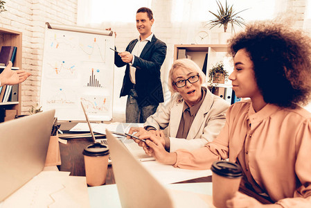 学生习商业和金融老师在提问男学生有答案其他学生正在互相交谈学生是
