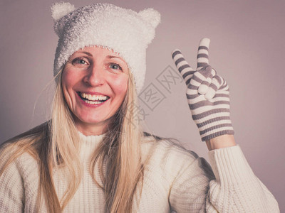 充满热情美丽笑容的女士在冬季孩子们用耳朵和肖像头戴起孩子帽时图片