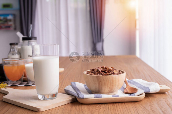 在的木桌上放着一杯牛奶的麦片早餐图片