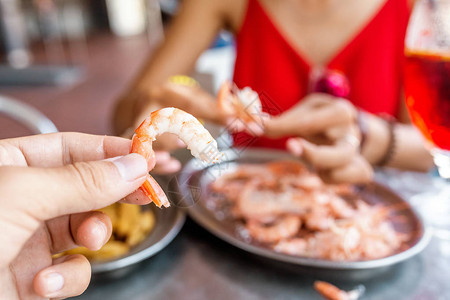 戴帽子的亚洲快乐女人吃着当地西班牙菜食美图片素材