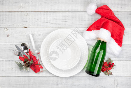 圣诞餐桌设置与一瓶香槟玻璃白色背景上的红色v顶视图顶视背景图片