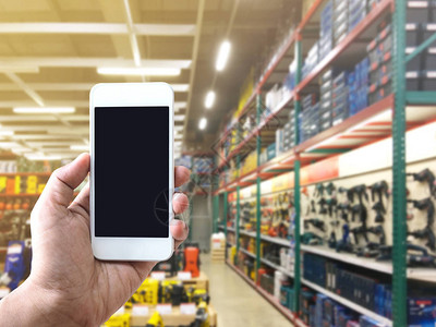 网上购物和电子商务的互联网概念手持机在五金店货架上的电动工图片
