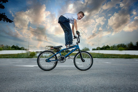 近距离看年轻运动骑自行车的男孩在自行车上玩鲁莽的把戏图片