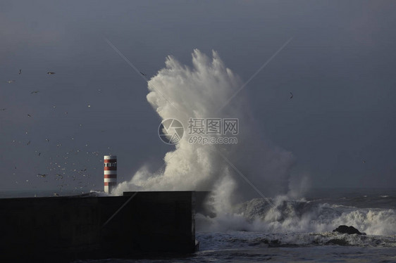 大海浪向雨天喷洒杜罗河口南码头和信标图片