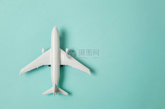 蓝色柔和彩色纸时尚背景上的简单平躺设计微型玩具模型飞机乘飞机度假夏季周末海上冒险之旅程图片