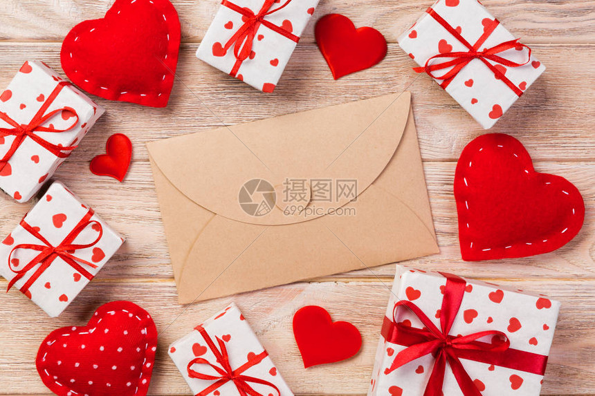 用红色的心和礼品盒在橙色木制的信封邮件情人节贺卡爱情或图片