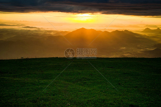 日出景观戏剧天空云山背景上山绿草上的早晨美丽的日出图片