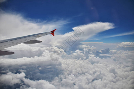 高空云层飞行高度期间飞机翼下的云背景