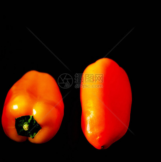 黑色背景的红胡椒和黄辣椒健康和美味的素图片
