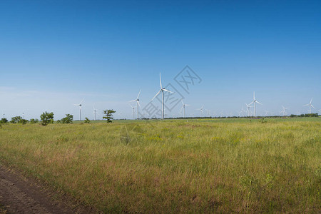 绿地和蓝天空中风力发电机涡轮图片